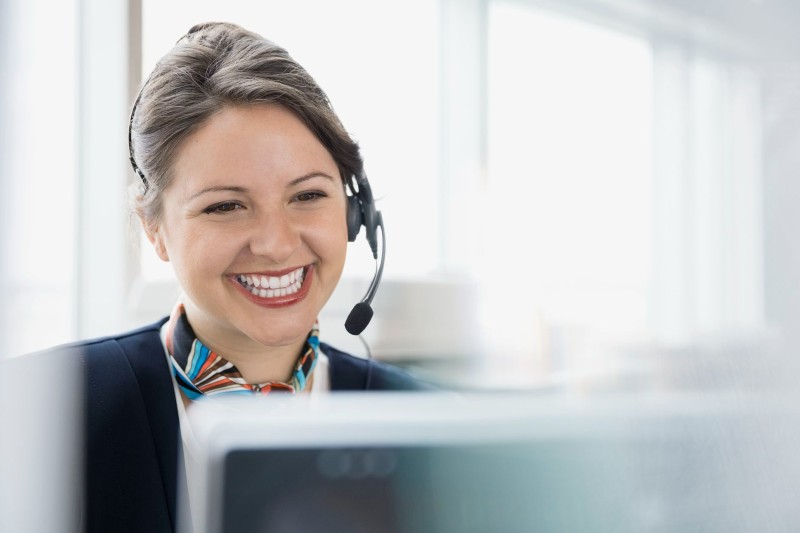 Happy smiling customer support female taking call for email campaign